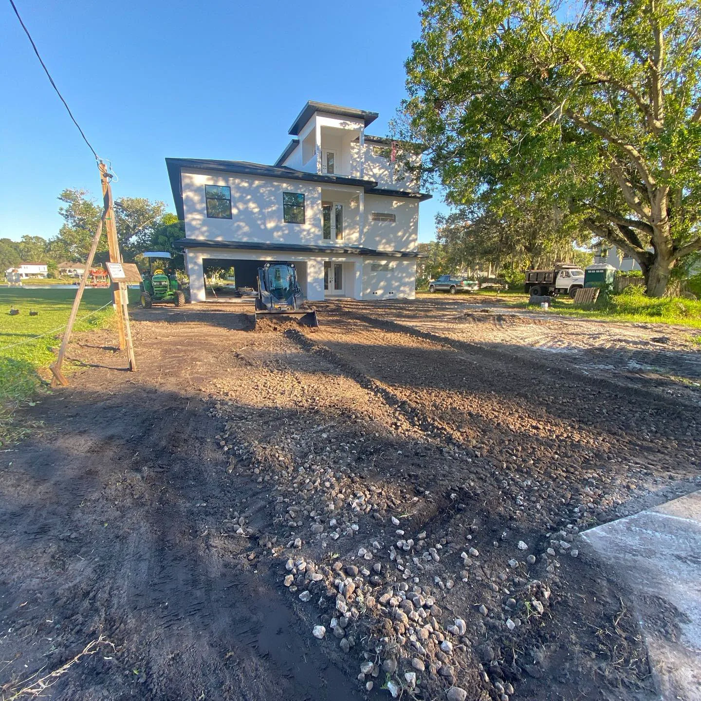 Graded gravel and dirt yard around a new construction home
