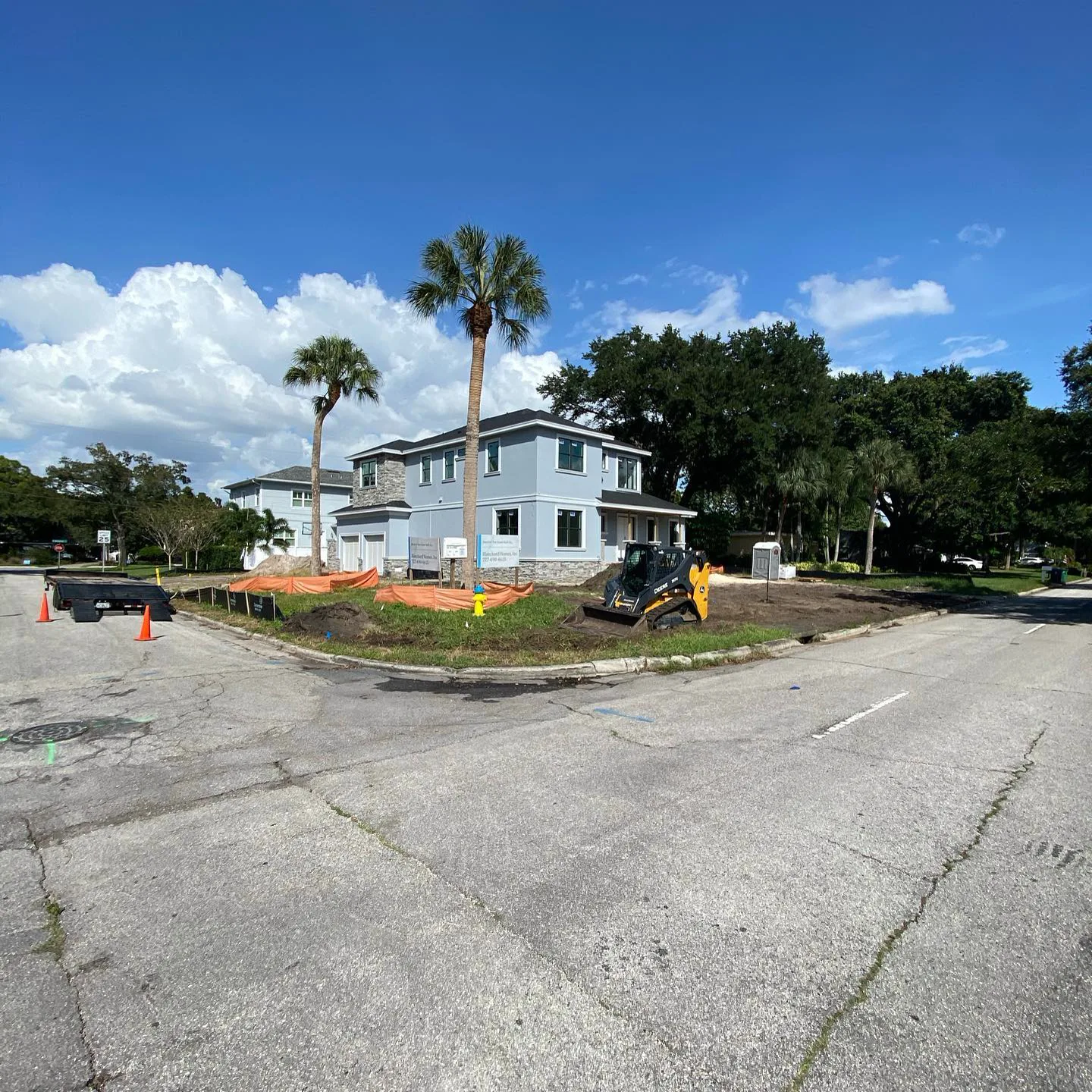 Skid steer finish grading a residential lot from the street